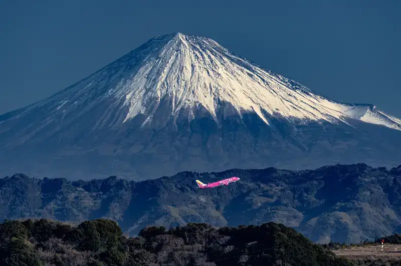 富士山を背景に静岡空港を離陸するピンクの3号機