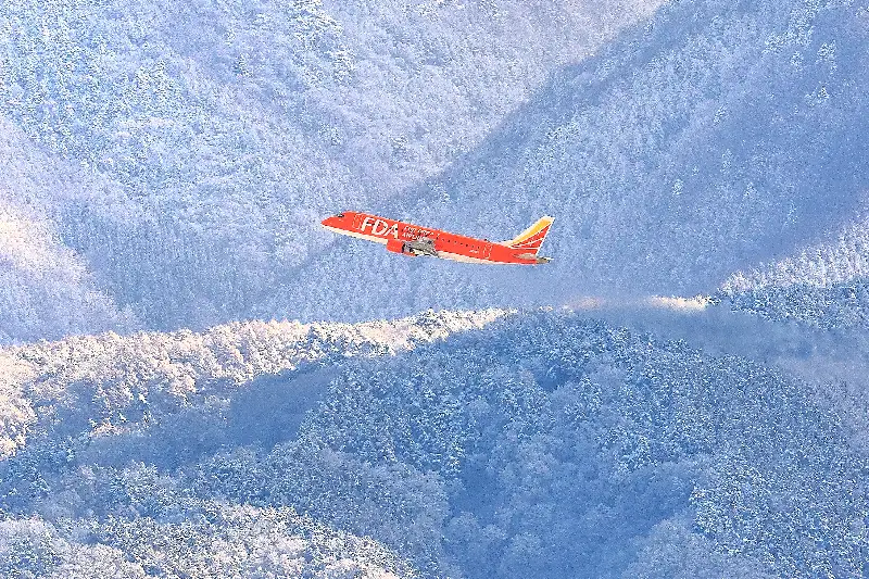 霧氷の木々を背景に松本空港を離陸するオレンジの5号機